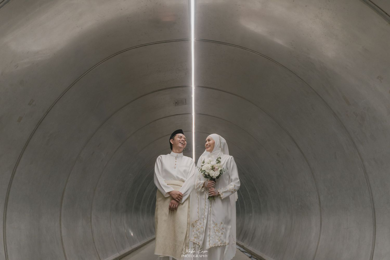 A couple shares joyful moments while walking together in a lush outdoor setting.