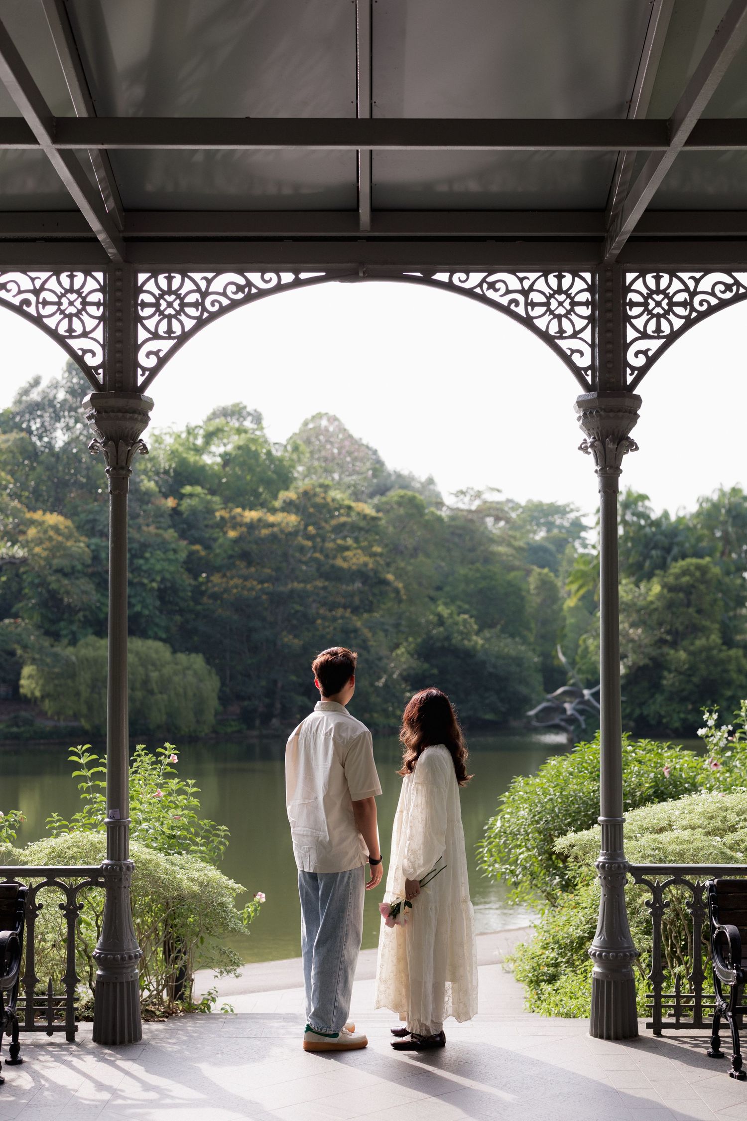 Couple dancing in a bright sunlit room with white walls and large windows.