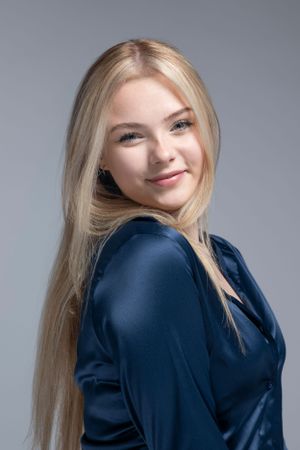 Studio fashion portraits in navy blue top showing different poses against grey background.