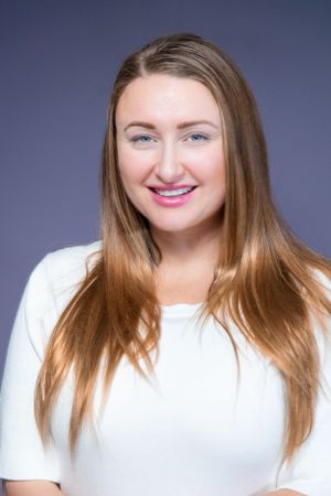 Professional headshots in white top showing various expressions against blue backdrop.