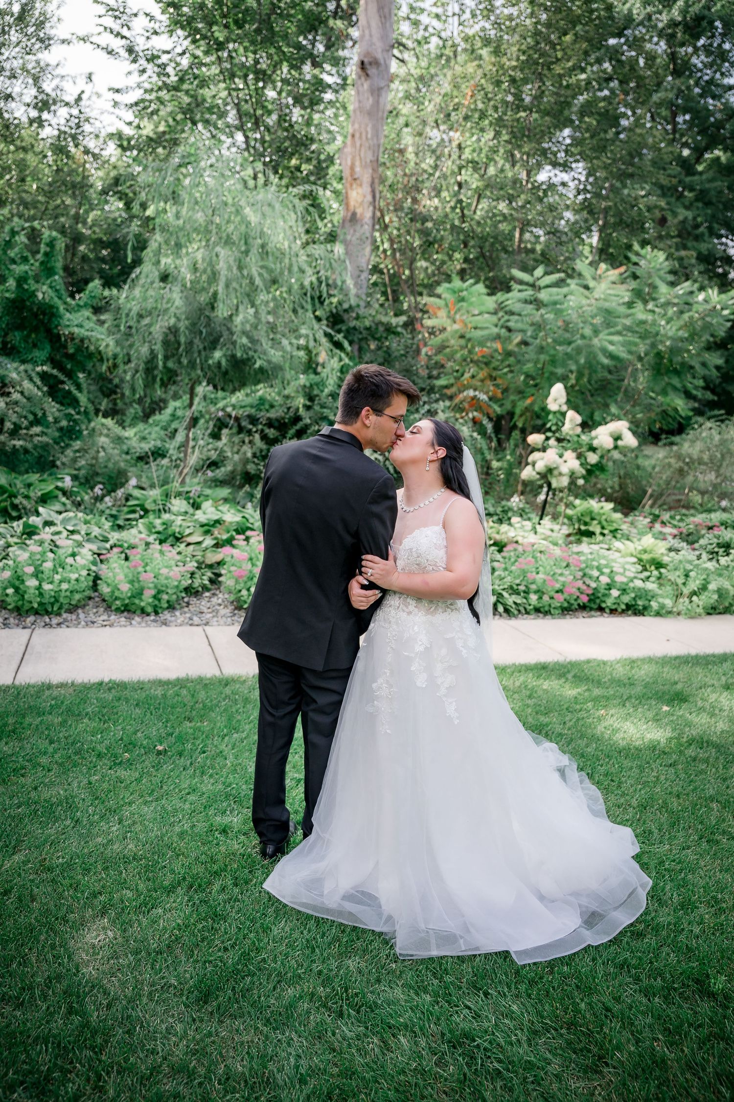 A romantic wedding portrait on an elegant staircase with ornate gold railings.
