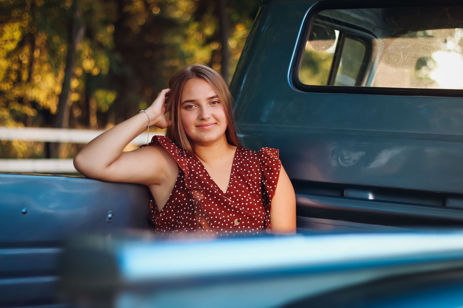 Portrait series taken next to vintage blue car during golden hour lighting. Senior photography