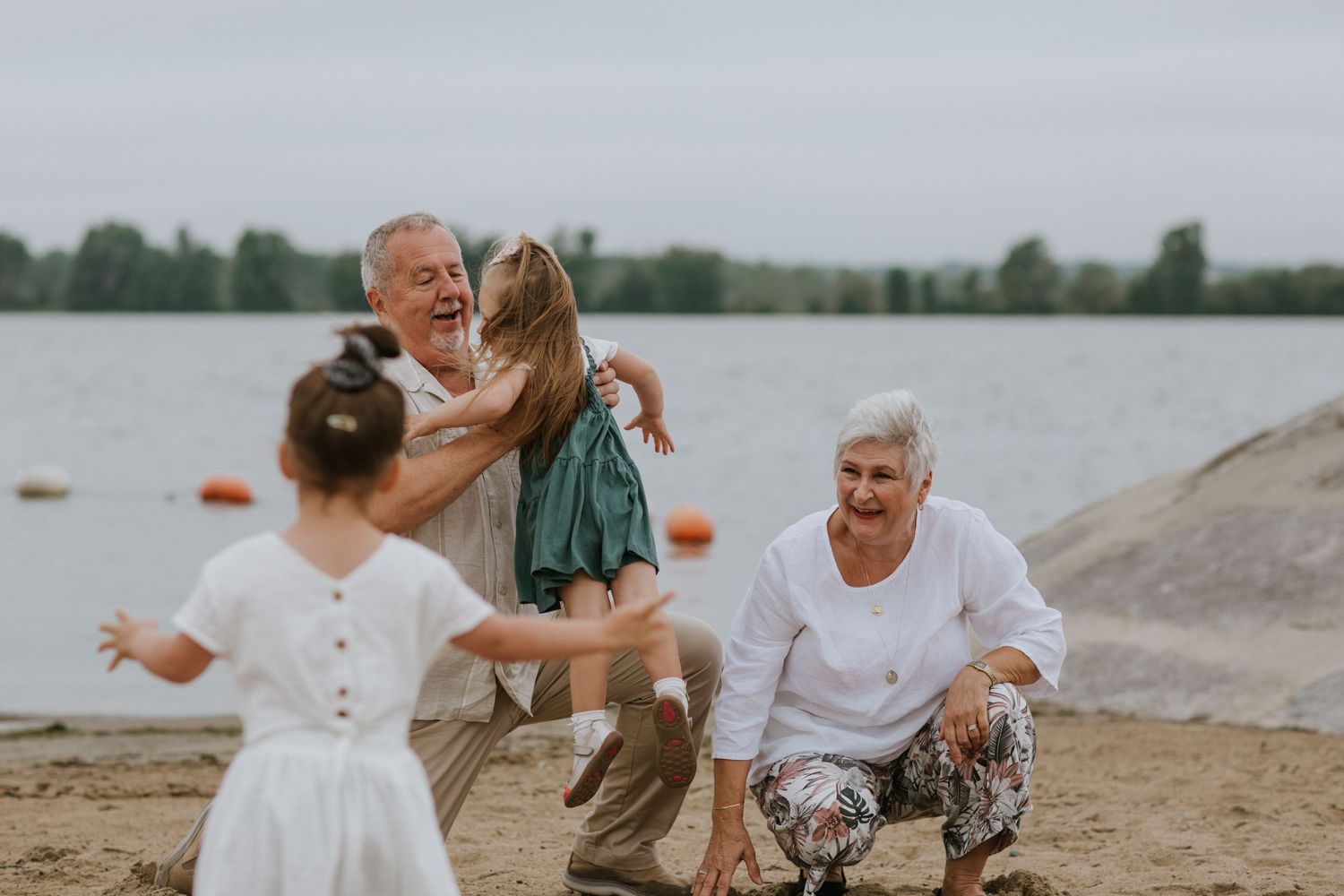 Family members celebrate joyfully on beach during seaside gathering.