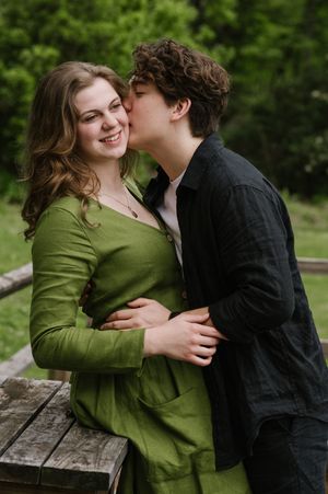 a woman in a green linen dress being kissed by a man in Birmingham alabama