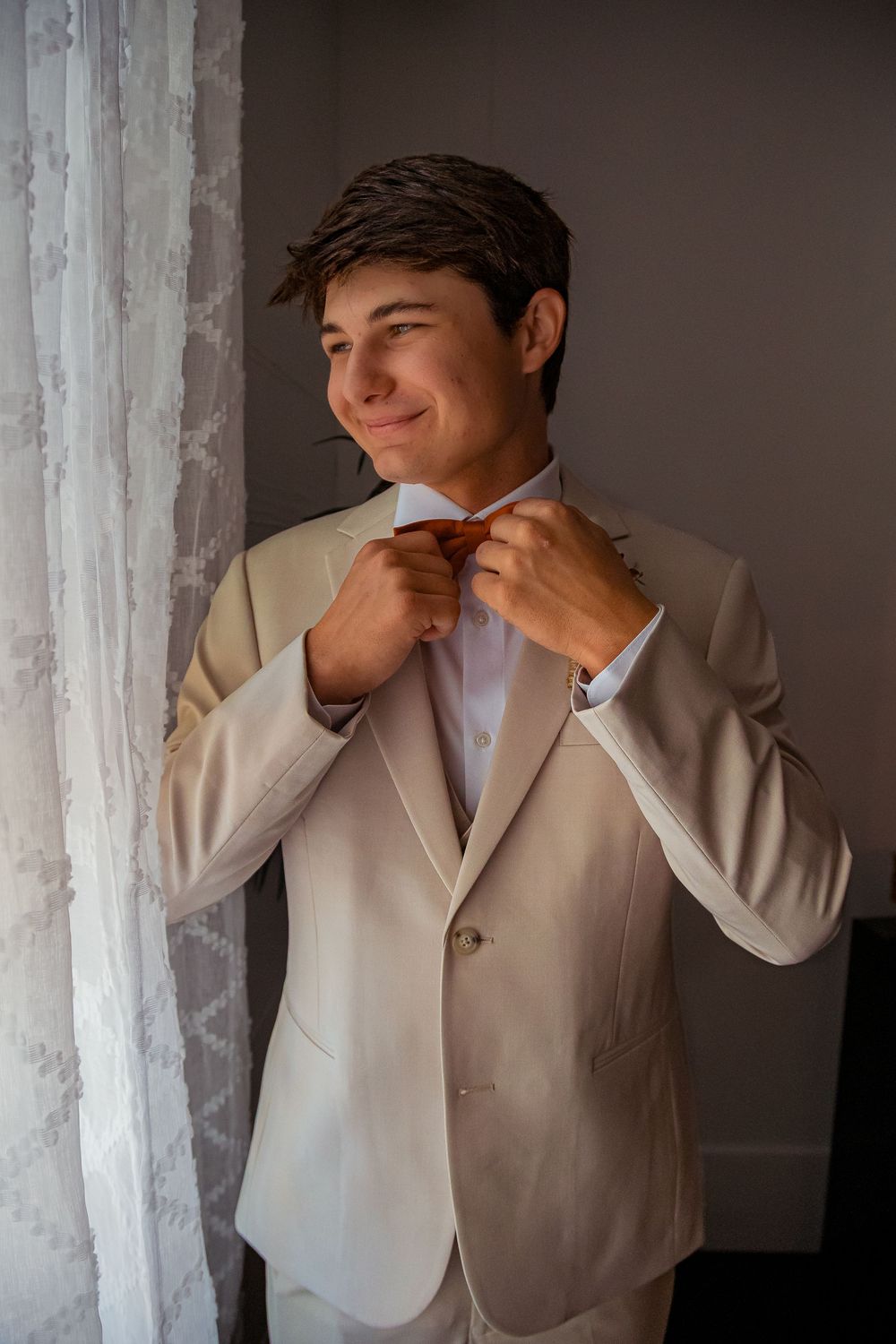 A series of emotional expressions shown by someone wearing a light beige suit jacket against a white wall.