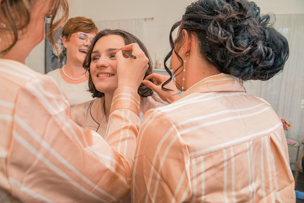 A couple shares an intimate embrace while dancing together in a peach-tinted room.