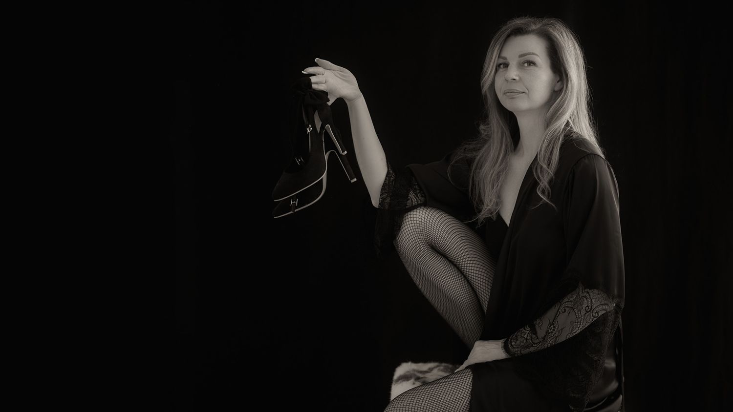 sinnliches Frauenportrait mit Stöckelschuhen in der Hand