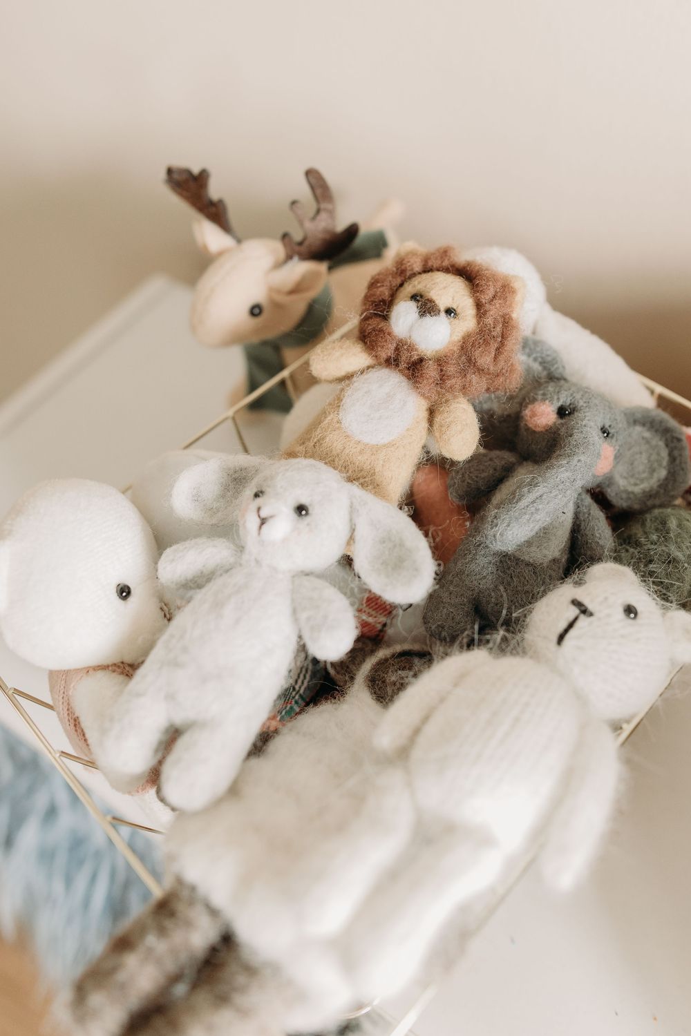A collection of soft plush stuffed animals including a reindeer, lion, bunny, and other cuddle toys arranged together.