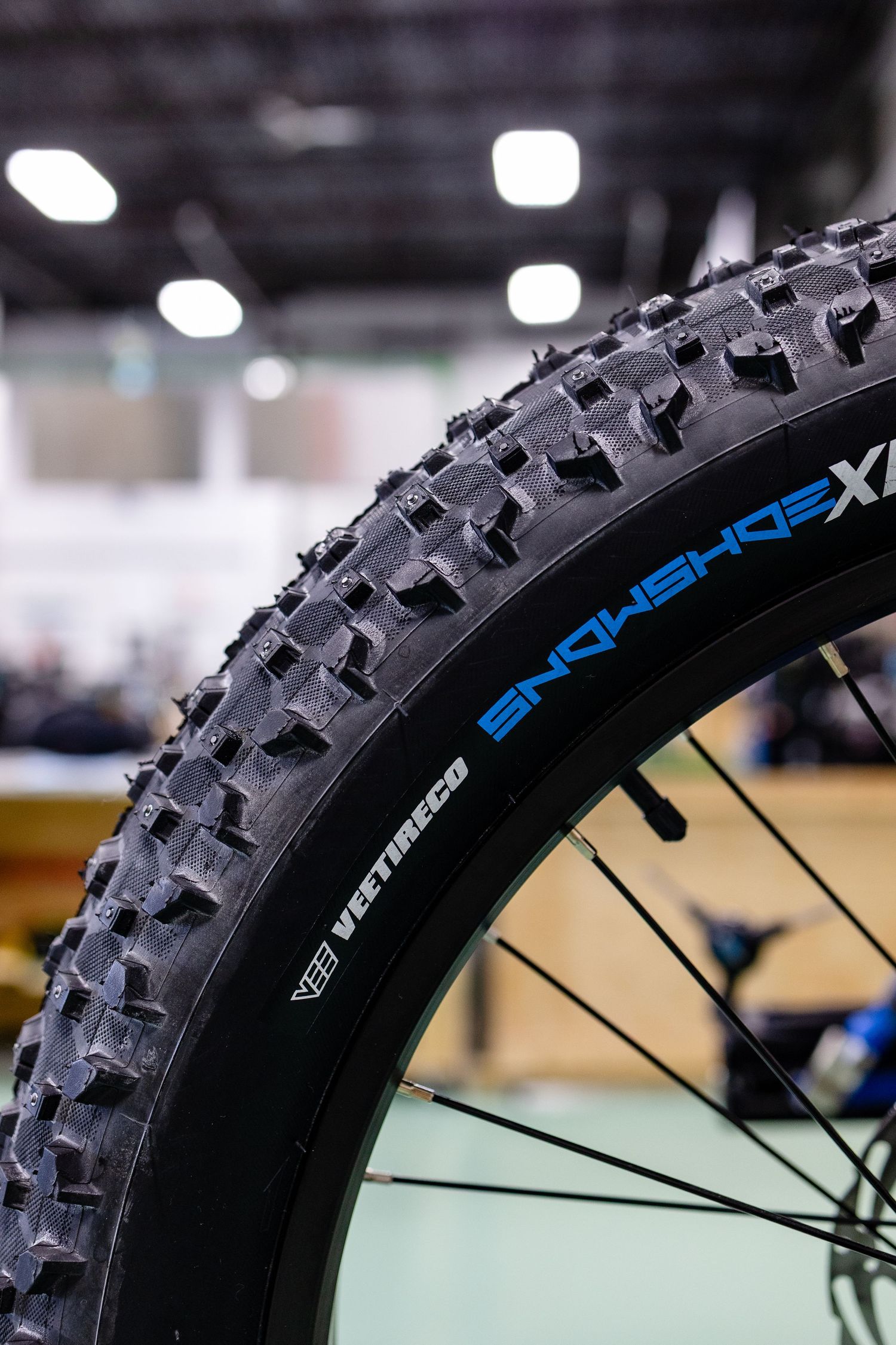 Close-up of aggressive mountain bike tire tread pattern with blue text branding.