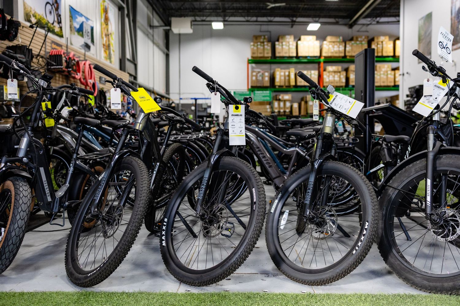 Multiple black electric bikes lined up in a row at a retail store display.