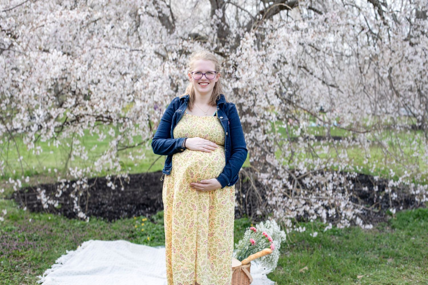 Maternity photos under cherry blossoms in Cincinnati capturing expecting parents in elegant, high-end outdoor portraits for premium clients