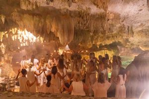 Group celebration in a dimly lit cave with glowing ambient lights.
