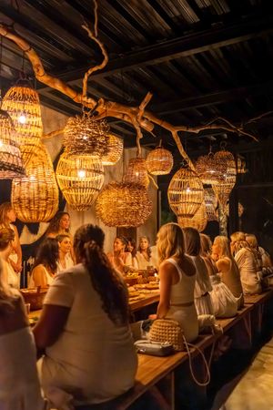 Elegant restaurant interior with crystal chandeliers hanging from rustic wooden beams.