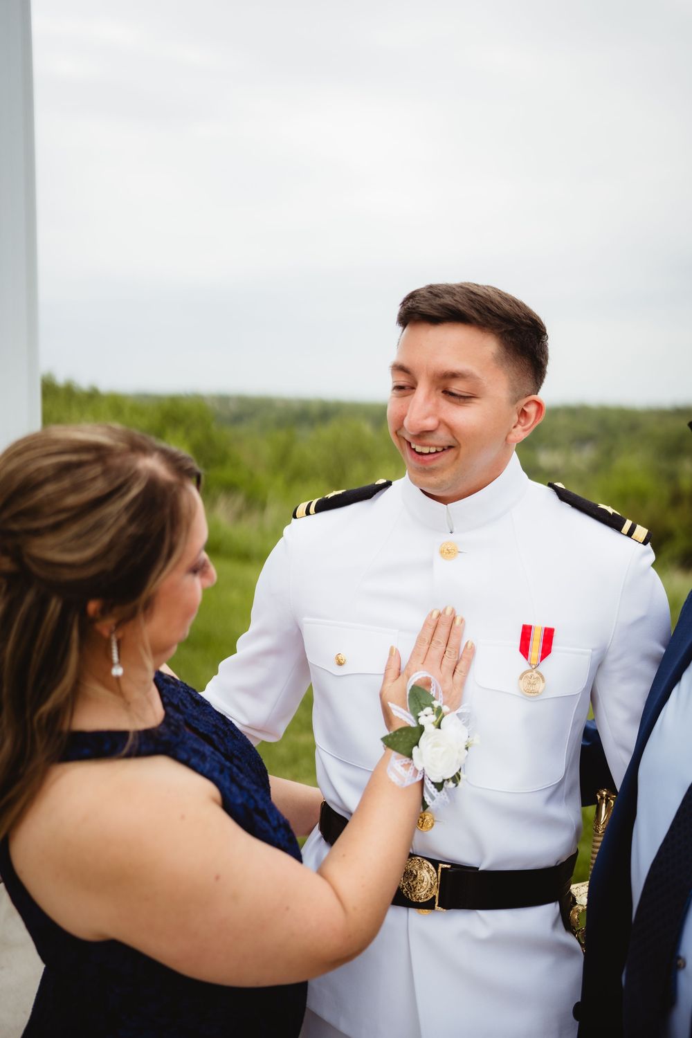 A heartwarming moment between people as they share a conversation, with one wearing a formal white military dress uniform.