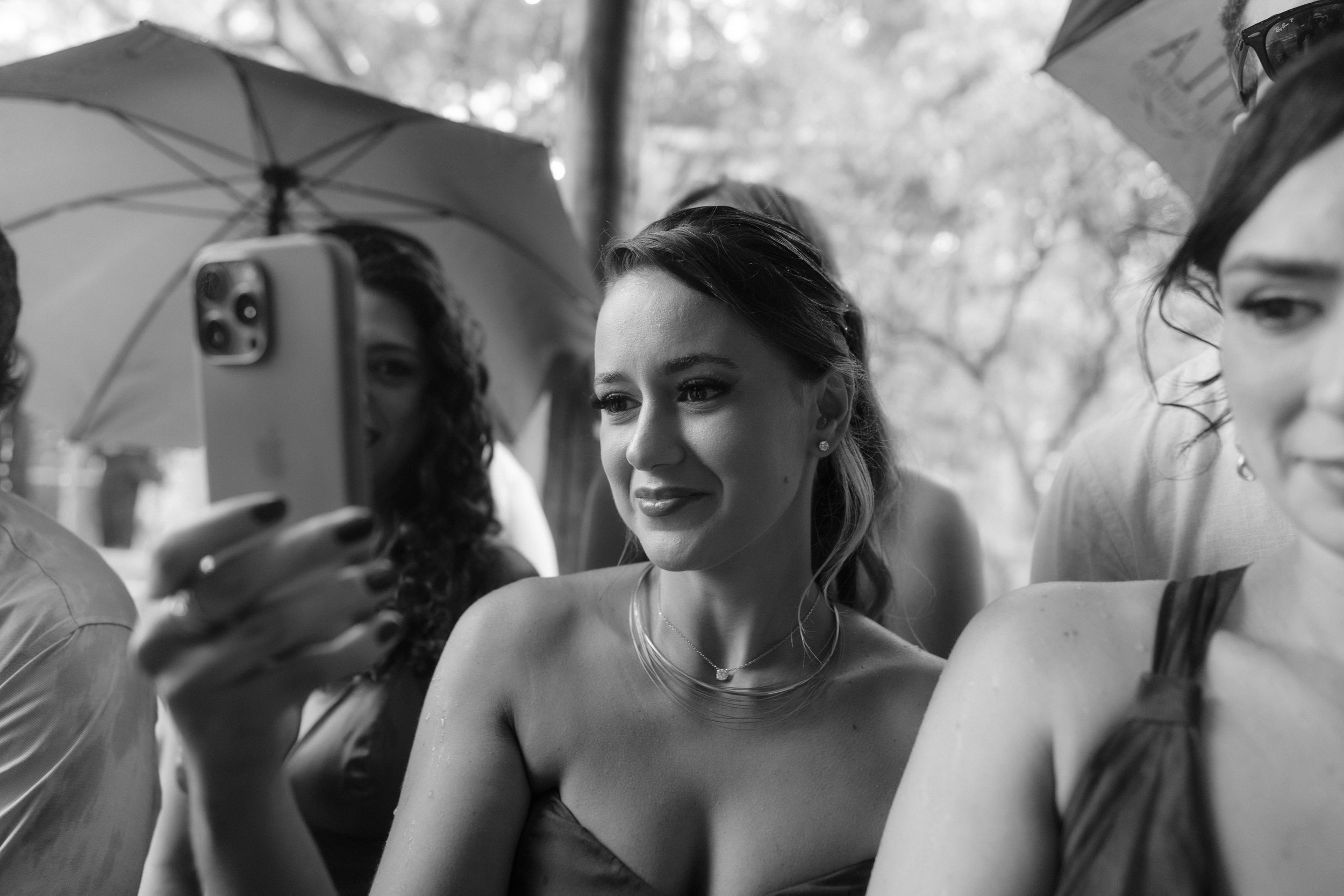 Black and white candid wedding celebration photos showing guests mingling at an outdoor event.