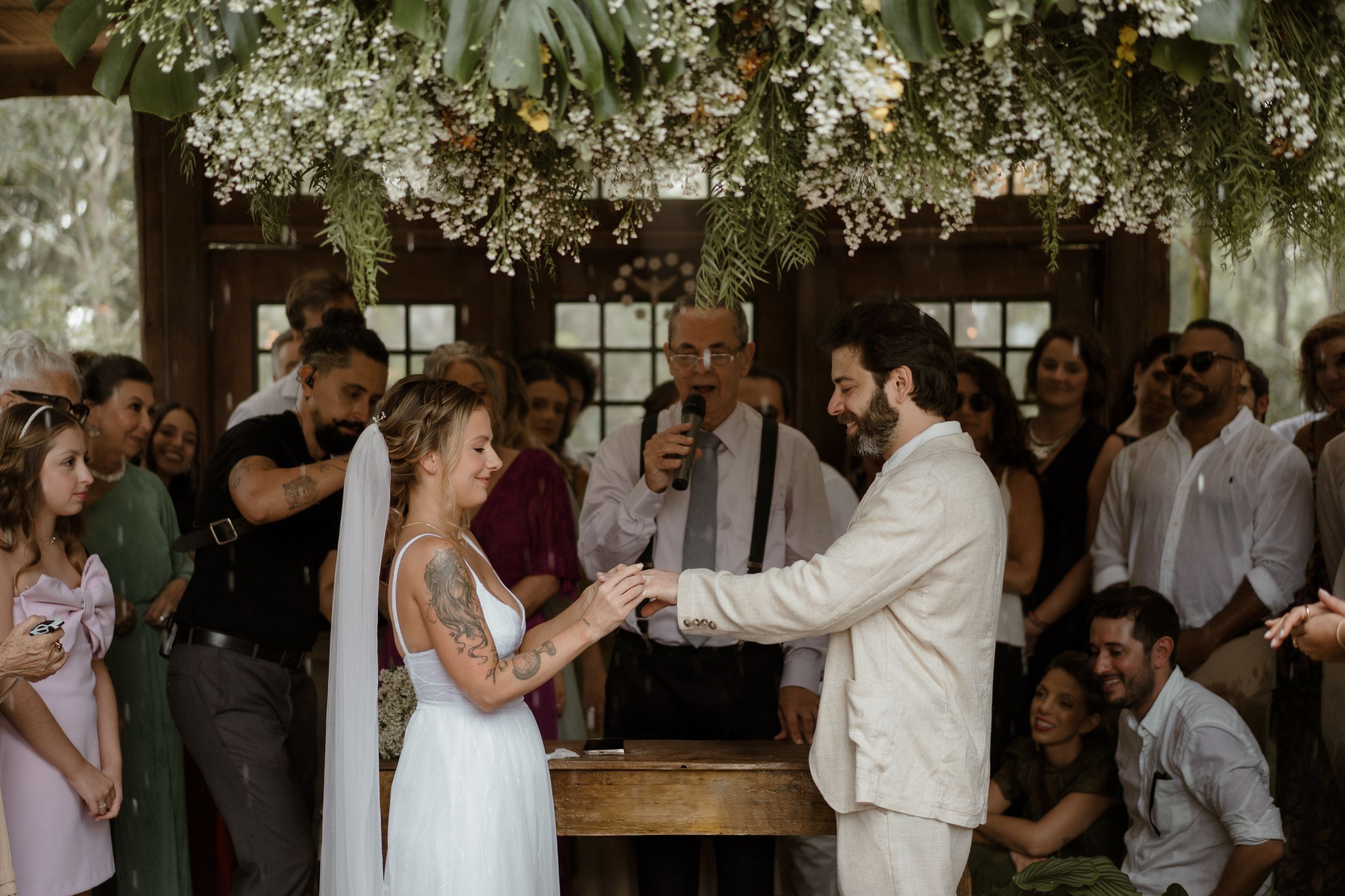Wedding reception venue decorated with floral arrangements and string lights.