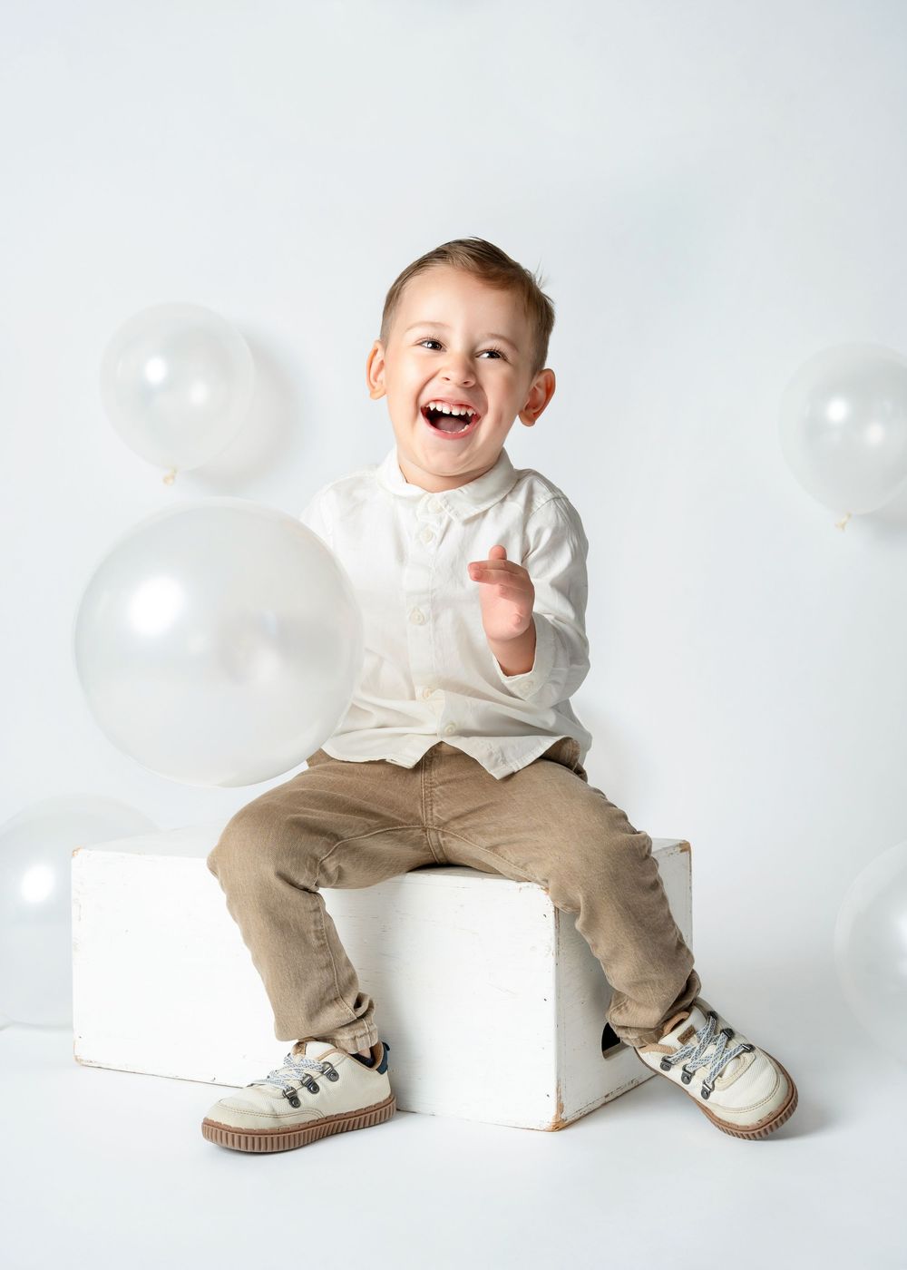 a young boy laughs in a white studio for a minneapolis photographer