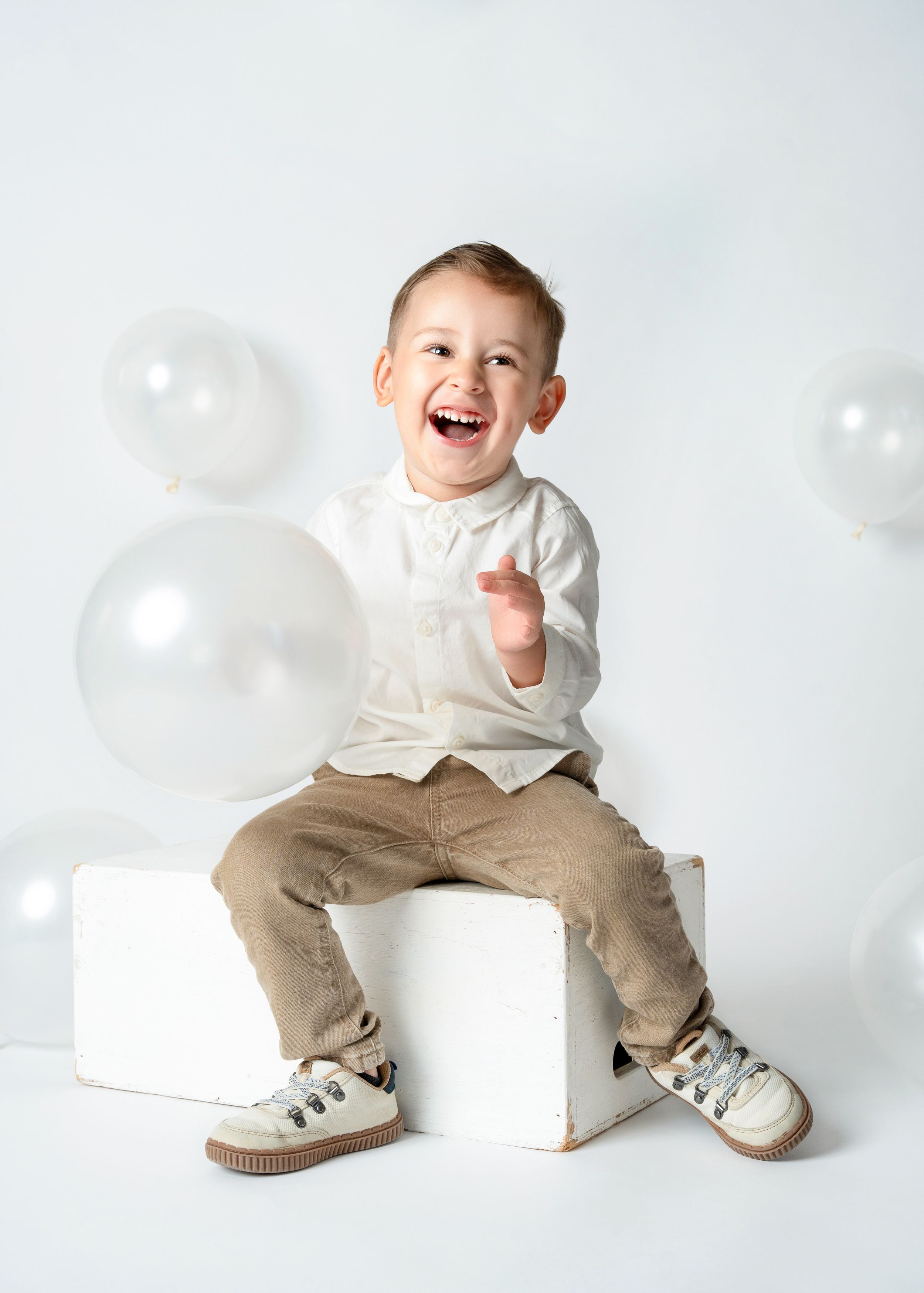 a young boy laughs in a white studio for a minneapolis photographer