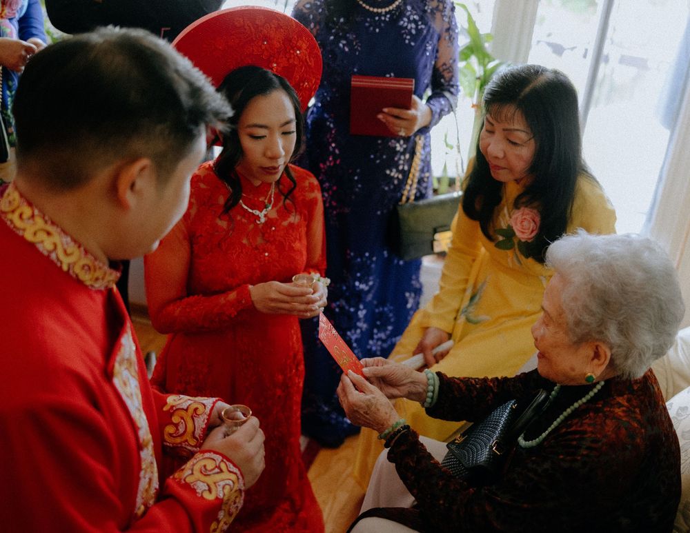 Elderly resident receives traditional red envelope gifts during Lunar New Year celebration at senior care facility.