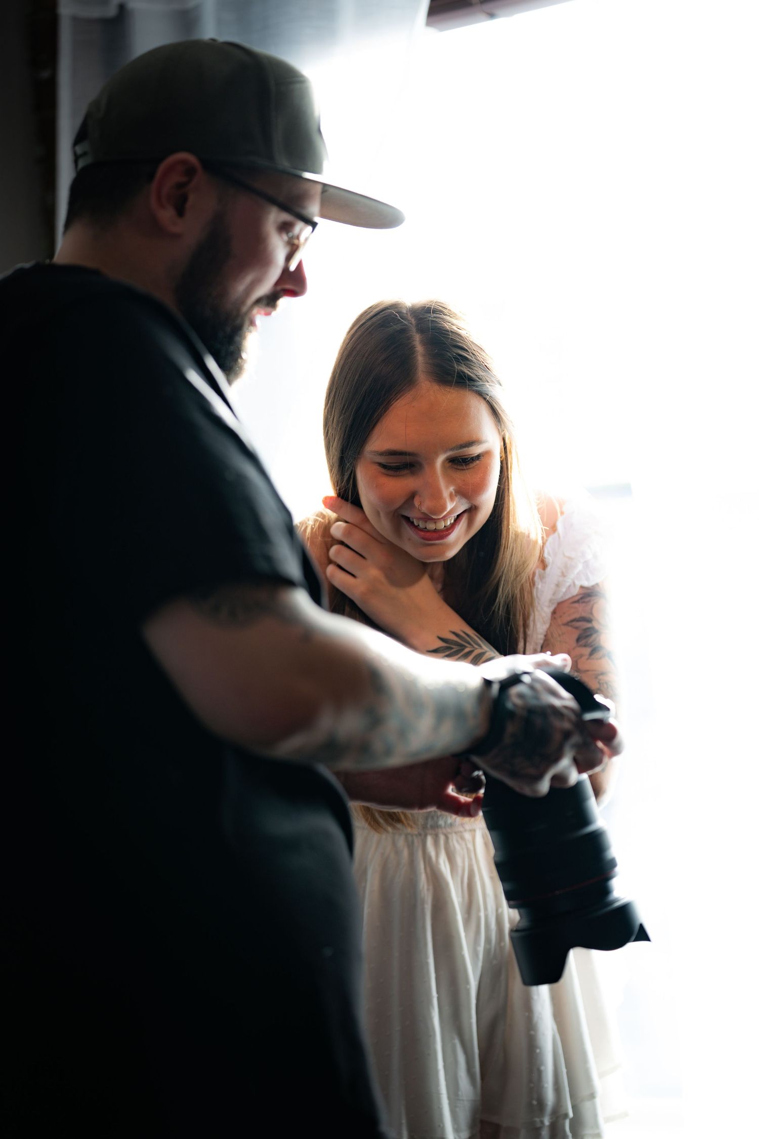 A photographer shows his client a photograph on the back of his camera.