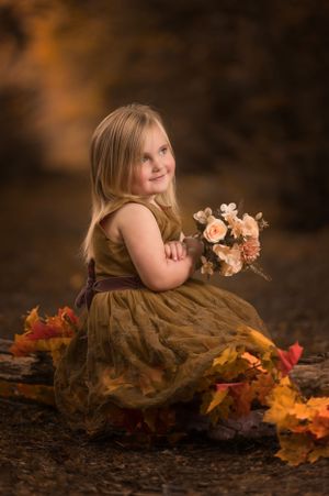 Artistic fall photo with soft lighting and scattered autumn leaves on dark ground.