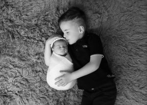 Black and white newborn portraits with textured background and minimalist styling.