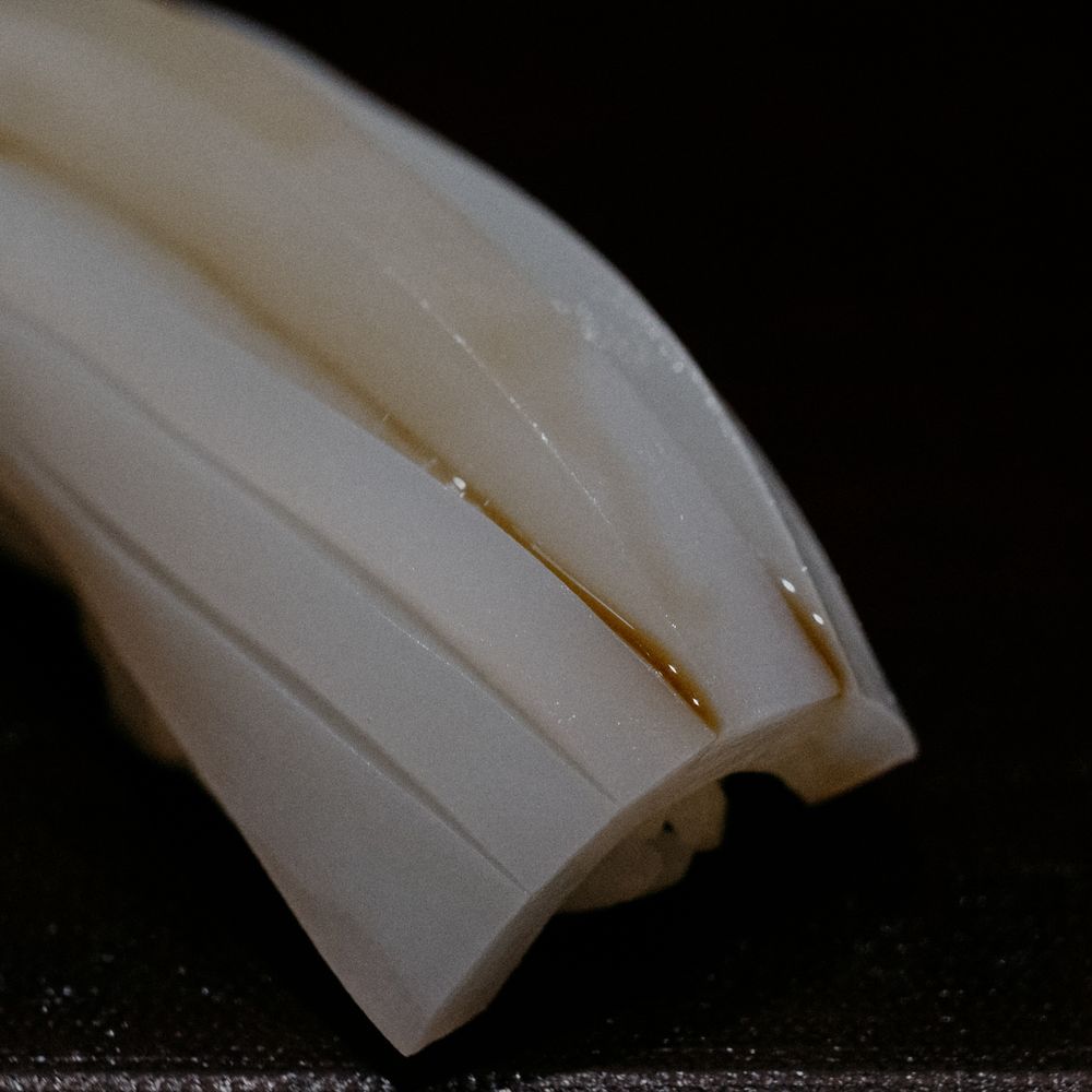 Close-up detail of white fish sushi showing precise diagonal slicing patterns.