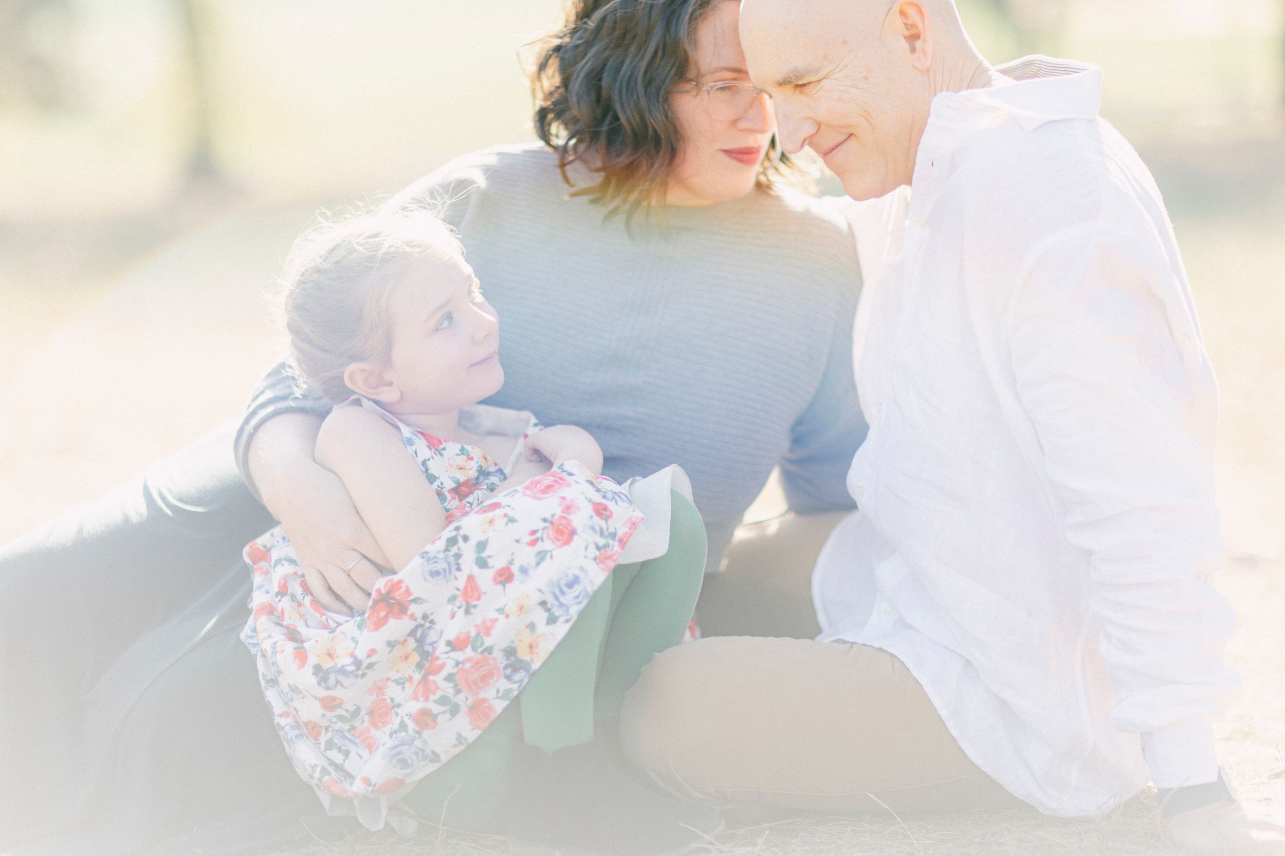 An intimate family moment captured in dreamy pastel tones during golden hour.