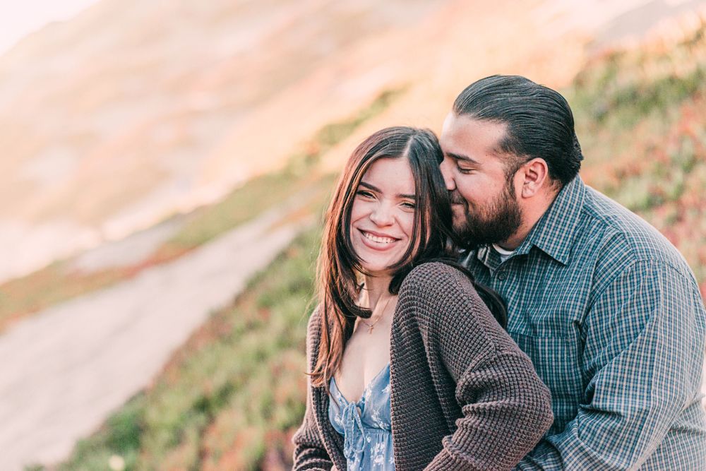 A joyful couple sharing a laugh during their outdoor photoshoot.