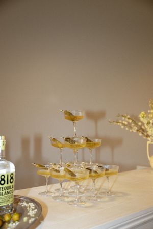 Tiered display of champagne cocktails arranged on a white bar counter.