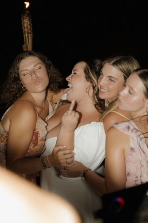 A group of wedding guests sharing laughter and joy during an evening celebration.