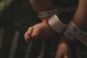 Medical professional in blue gloves performing a newborn health check.