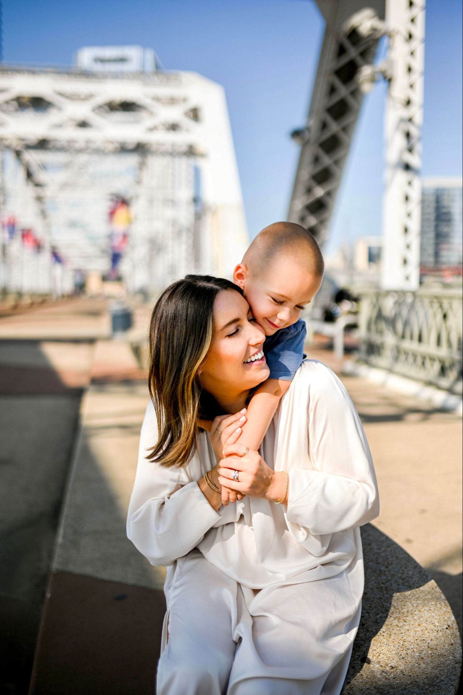 A sweet couple sharing a romantic moment together on a bridge while wearing matching white outfits.