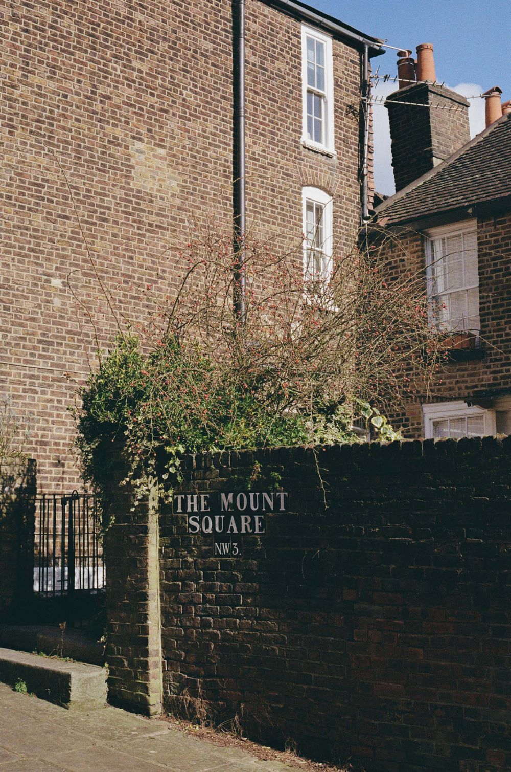 Brick building entrance with 'The Mount Square' sign on a dark wall.