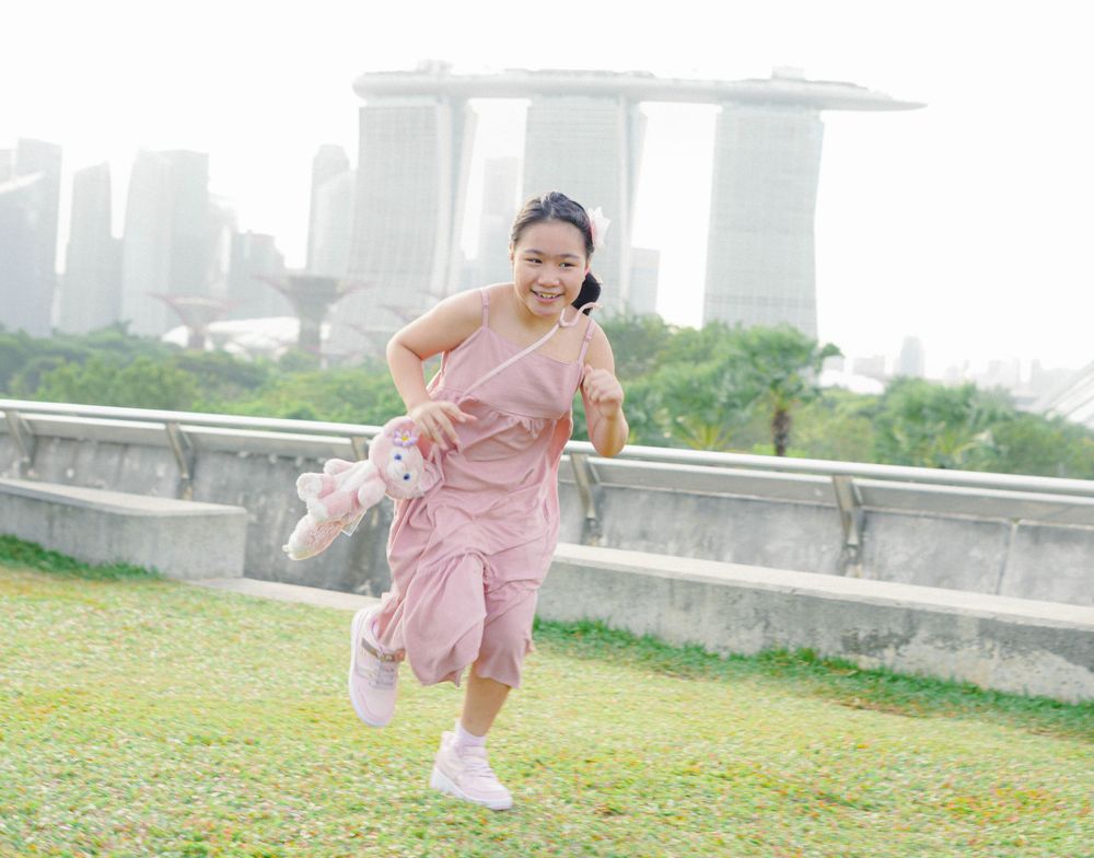 A joyful moment captured in Singapore park with the Marina Bay Sands skyline in the distance.