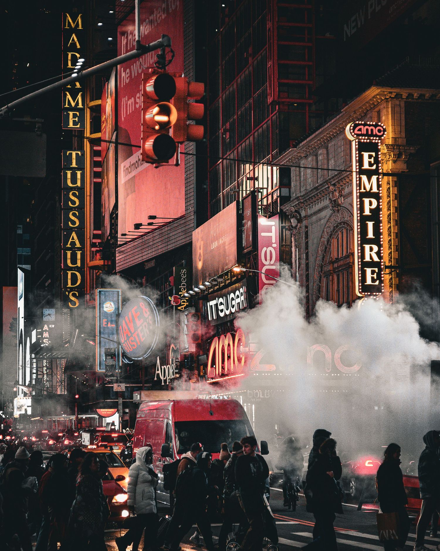 Foggy city street at night with illuminated signs and neon lights.