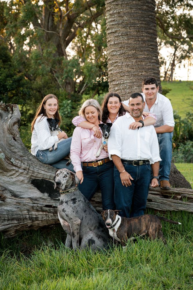 family photoshoot of three teenagers and four dogs in a beautiful green property with soft light in the central coast New South Weals