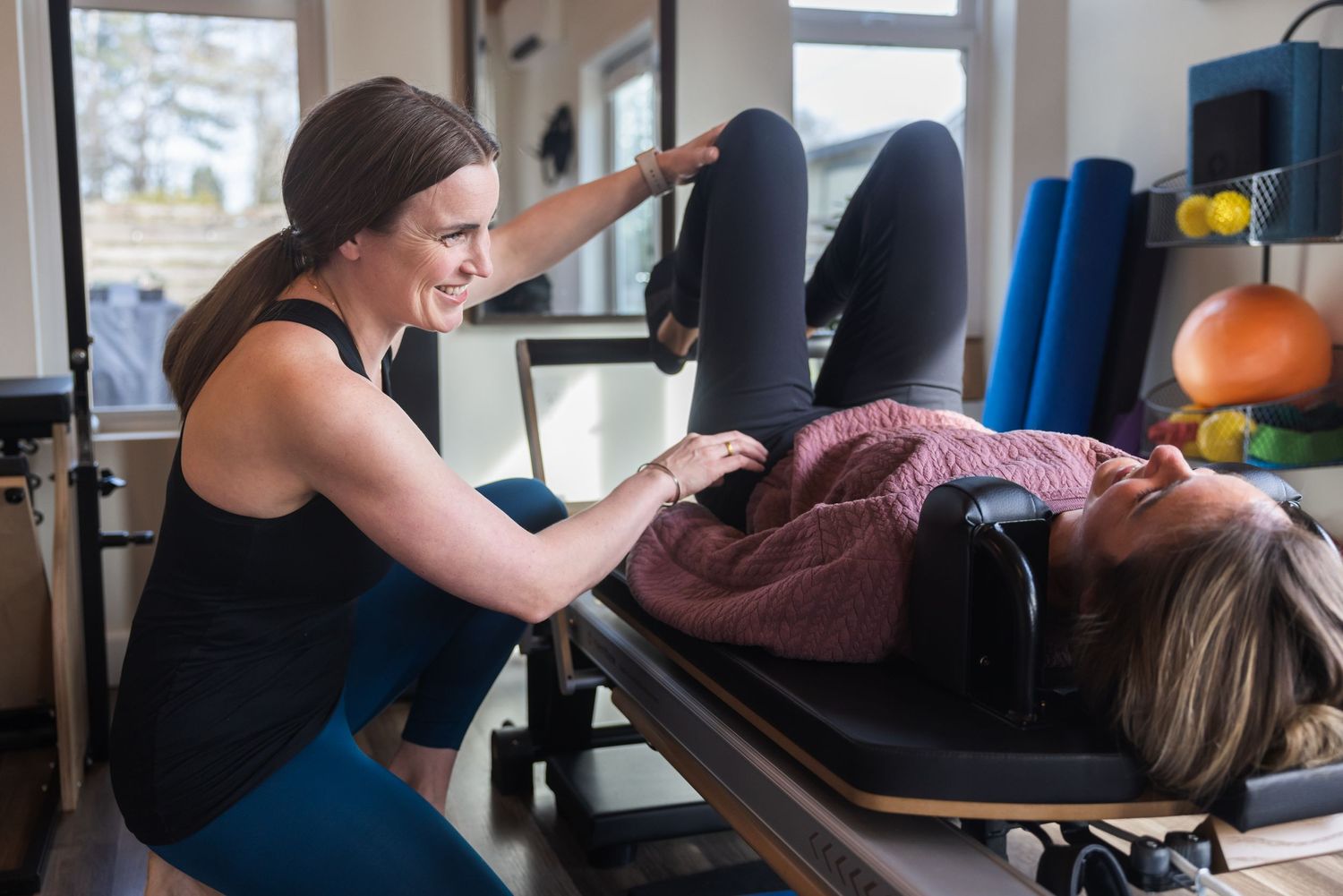 A physical therapist assists a patient lying on a treatment table during a rehabilitation session at a clinic.
