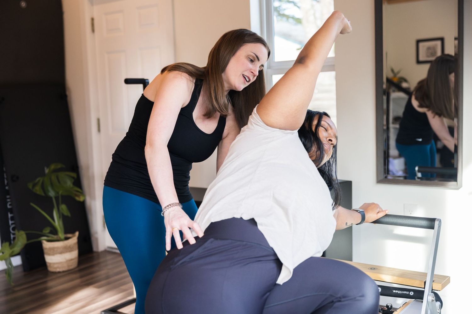 A physical therapist helps guide a patient through stretching exercises during a rehabilitation session.