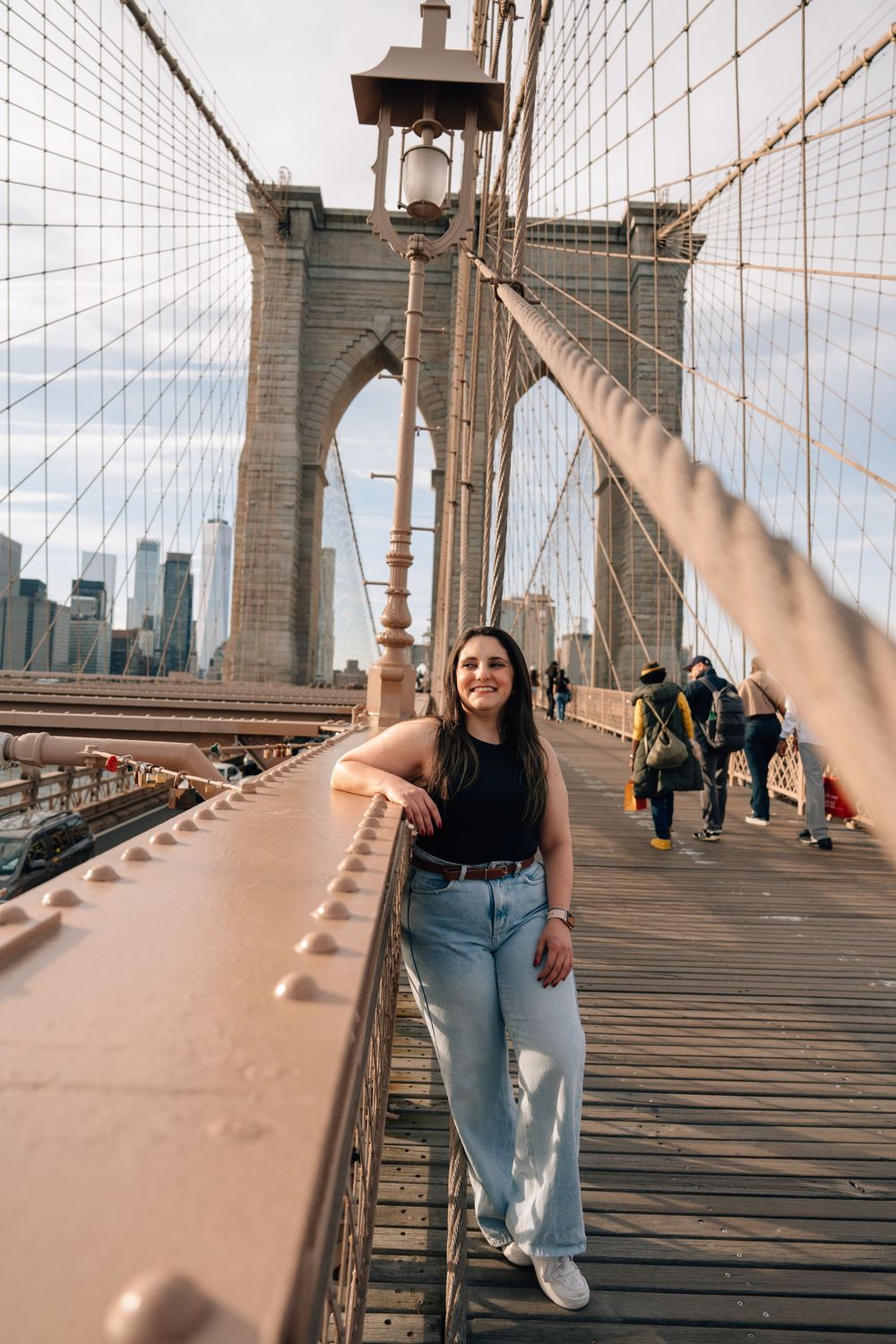 A series of photos showing someone walking across the iconic Brooklyn Bridge during golden hour in New York City.
