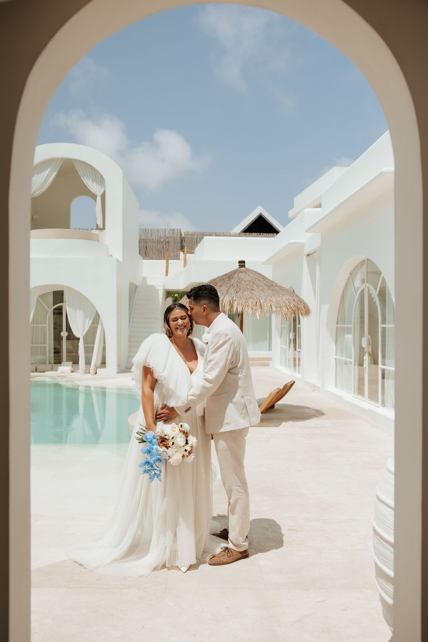 Elegant destination wedding venue with white Mediterranean architecture and pool.