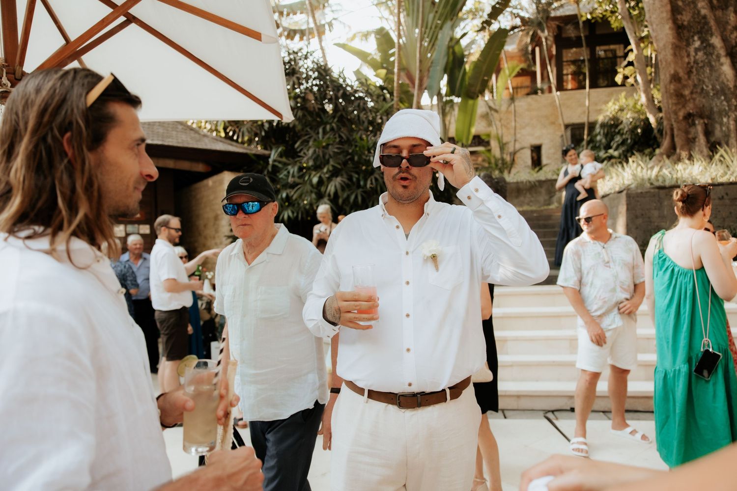 Guests in light summer attire enjoying an outdoor wedding celebration.