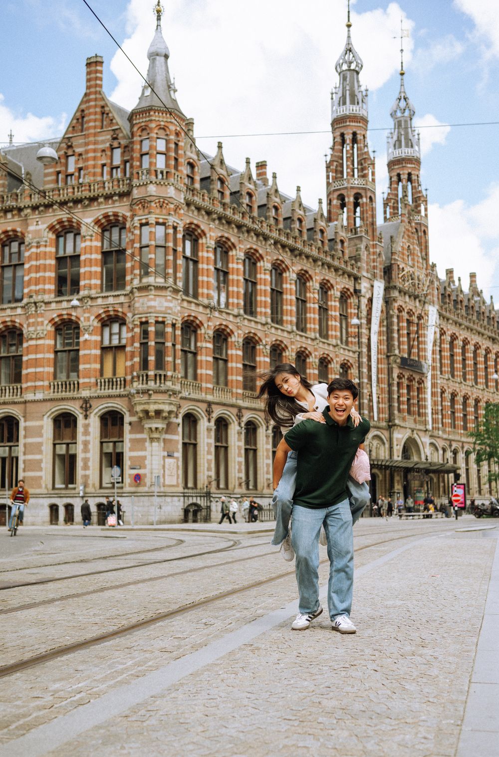 A sequence of playful poses in front of the ornate Gothic architecture of a European shopping arcade.