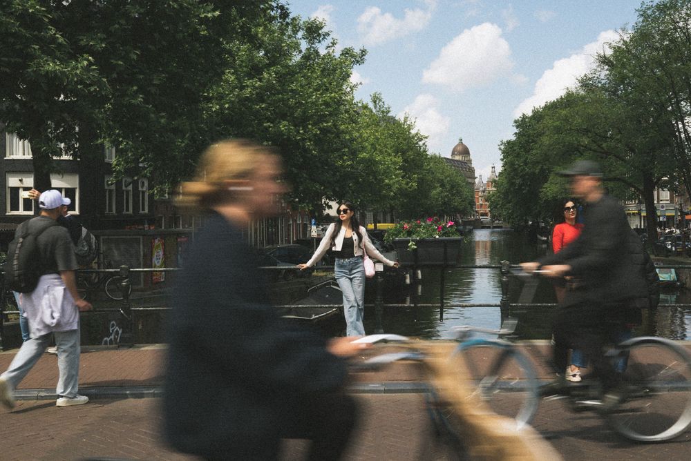 Multiple shots along Amsterdam's picturesque canal with trees and boats in view.