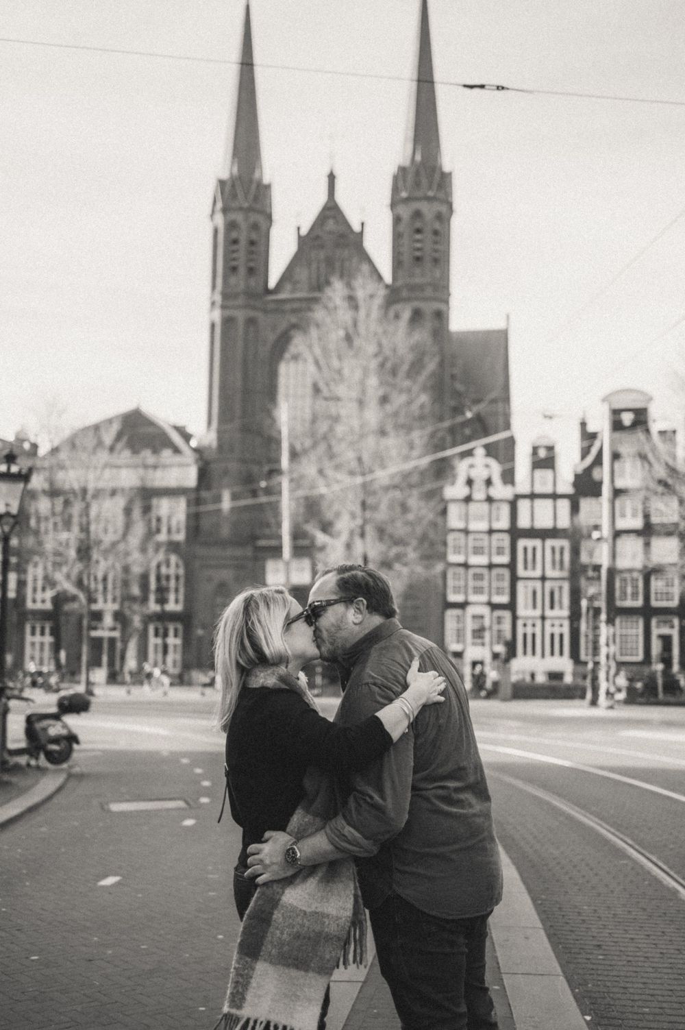 Couple sharing intimate moment in front of historic European church architecture.