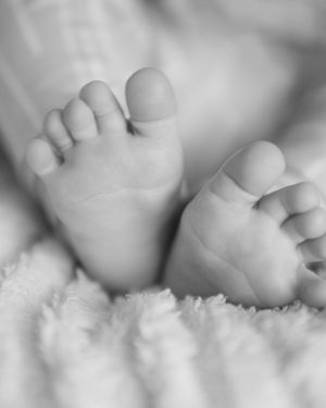 Tiny baby toes captured in timeless black and white, soft blanket background
