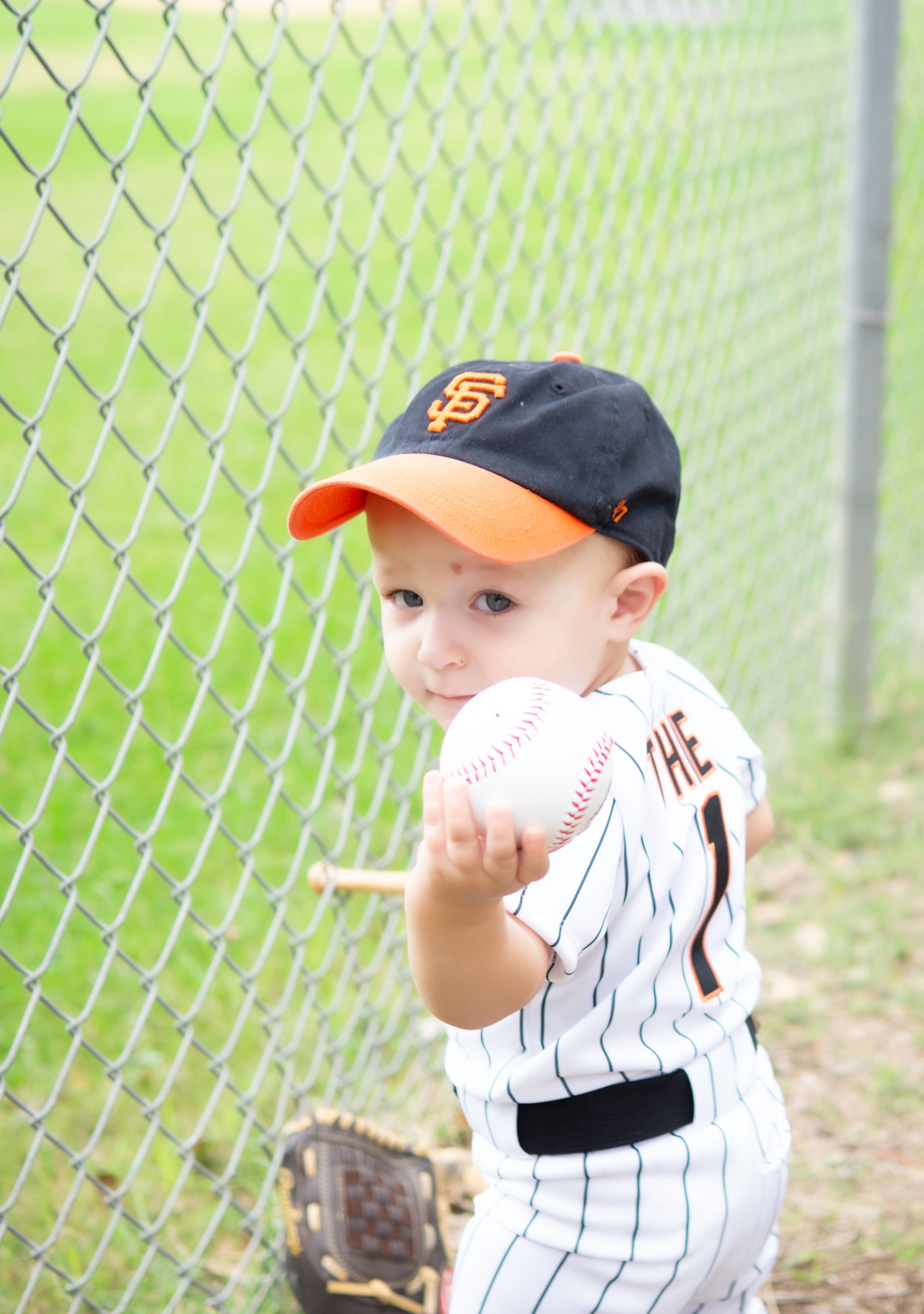 Candid milestone session, baby athlete theme, smiling while holding ball