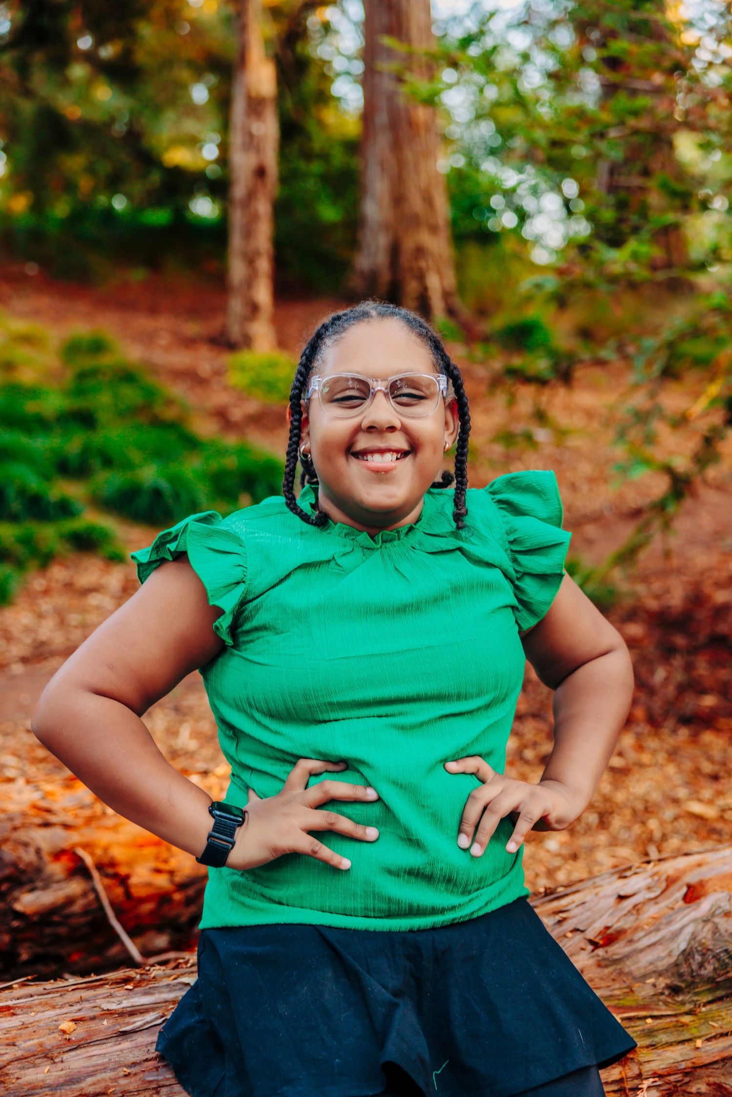A bright green ruffled top and dark skirt outfit worn in an autumn forest setting with fallen leaves.