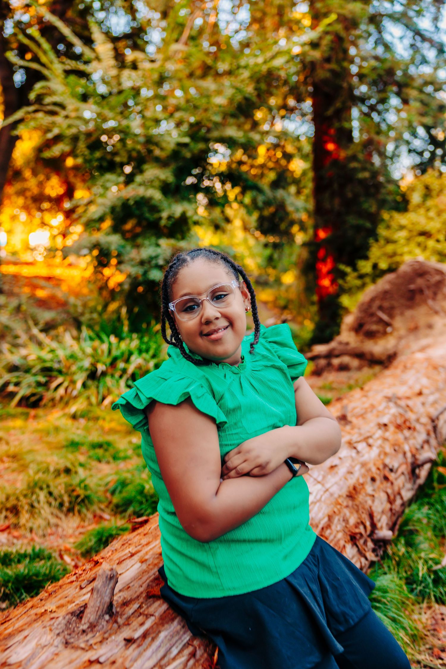 A person in a bright green shirt sits on fallen logs surrounded by warm autumn colors in nature.