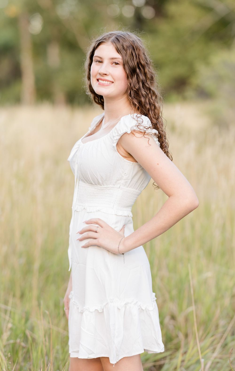 Multiple poses of someone wearing a white summer dress standing in a field with soft bokeh lighting effects.